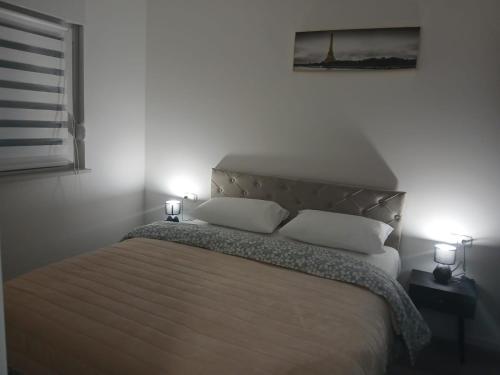 a bedroom with a bed with two white pillows at Apartman Herceg in Ljubuški