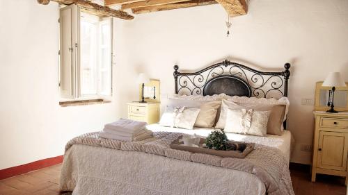 sypialnia z dużym łóżkiem z białą pościelą i poduszkami w obiekcie Rustico Dora w mieście Camaiore