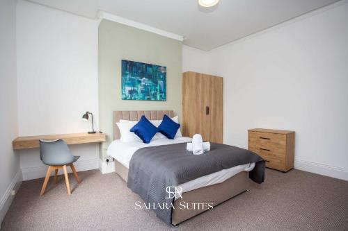 a bedroom with a bed with blue pillows and a desk at Luxury 6BR Ensuite - Contractors & Groups Stay - Parking in Sunderland