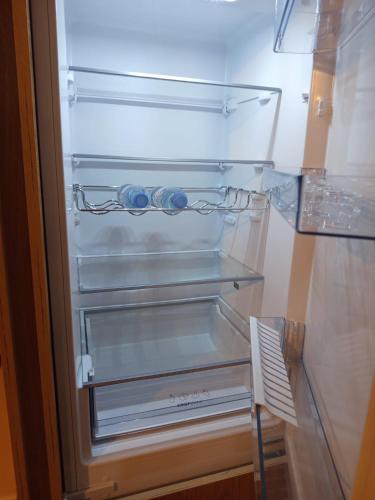 ein leerer Kühlschrank mit offener Tür und einem Regal in der Unterkunft L Évidence in Thonon-les-Bains