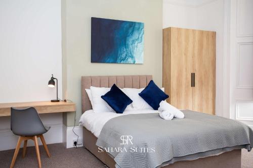 a bedroom with a bed with blue pillows and a desk at Luxury 6BR Ensuite - Contractors & Groups Stay - Parking in Sunderland