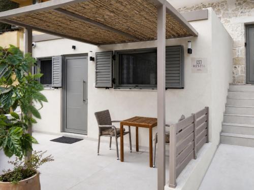 a patio with a table and chairs in front of a house at HESTIA Studio Georgioupolis in Georgioupolis
