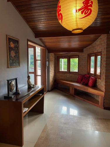 a living room with a table and a chandelier at Refúgio Alto do Pinhal in Santo Antônio do Pinhal