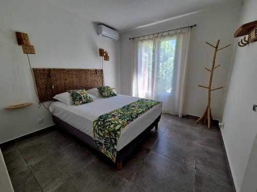 a bedroom with a bed and a large window at Ti case Margot - Maison avec piscine à Manapany in Saint-Joseph