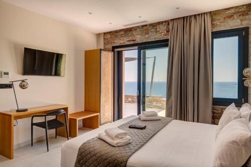 a bedroom with a bed with a view of the ocean at Pnoe Villas Syros in Megas Gialos - Nites