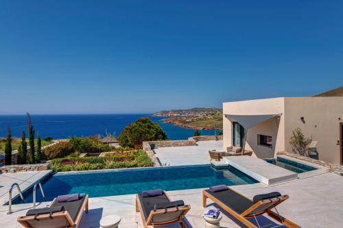 a villa with a swimming pool with a view of the ocean at Pnoe Villas Syros in Megas Gialos - Nites