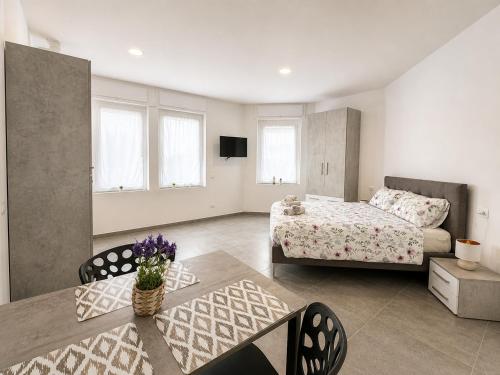 ein Schlafzimmer mit einem Bett, einem Tisch und einer Couch in der Unterkunft Mema Residence in Varallo Pombia