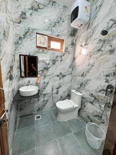 a bathroom with a white toilet and a sink at Singh Kainchi Dham Villa in Bhowāli
