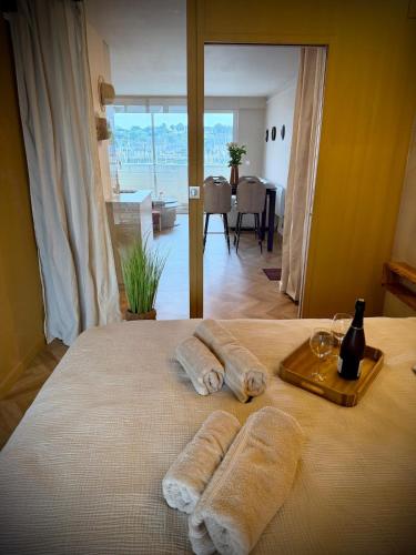 a bed with two towels and a tray of wine glasses at Elegance Bretonne in Pléneuf-Val-André