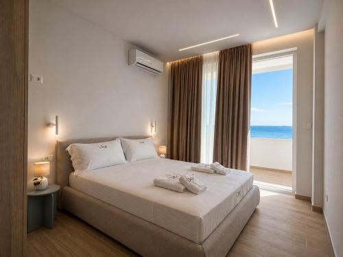 a bedroom with a bed with a view of the ocean at DoR Stay Seaside in Durrës