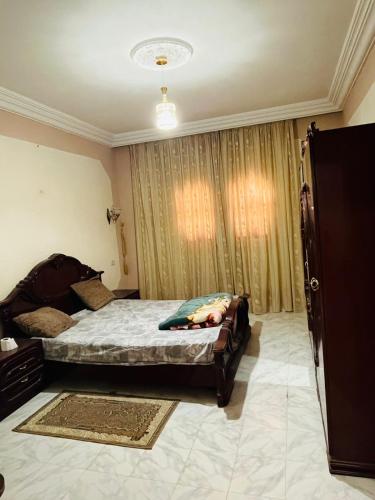 a bedroom with a bed and a window with curtains at Appartement Al Hanine in Douz