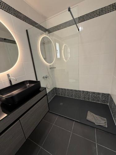 a bathroom with a black sink and a mirror at Corralejo Tender Suite in Corralejo