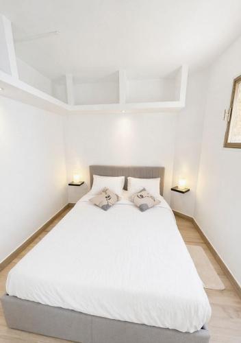 a bedroom with a white bed with two pillows on it at Seaside Apartment in Conca