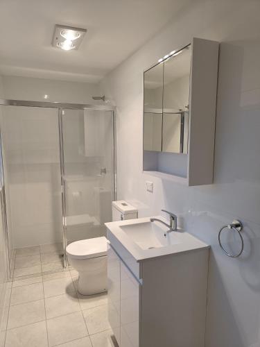 a bathroom with a toilet and a sink and a shower at Spacious and Comfortable Queen Room - NM1 in Merrylands