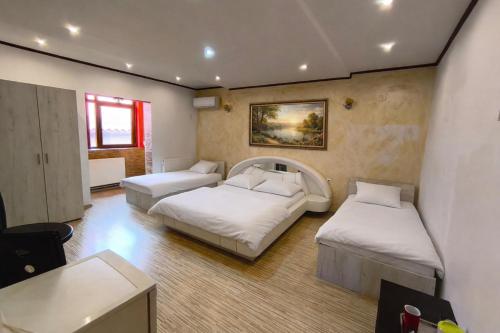 a room with three beds and a table and a desk at Vila Magica in Constanţa