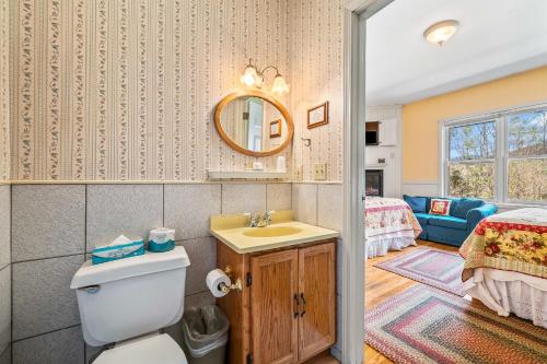 a bathroom with a toilet and a sink and a bedroom at Inn at Jackson in Jackson