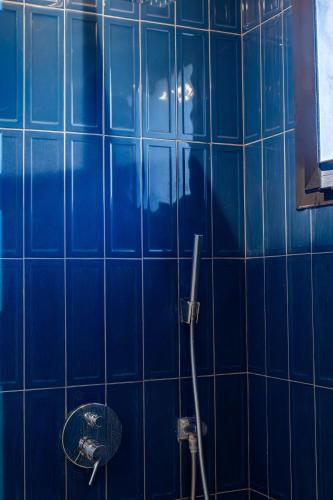 a blue tiled bathroom with a shower and a sink at Accès direct piscine - appartement avec jardin in Marrakesh