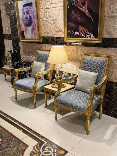 a room with two chairs and a table with a lamp at رمادان تربة للشقق المخدومة in Turbah