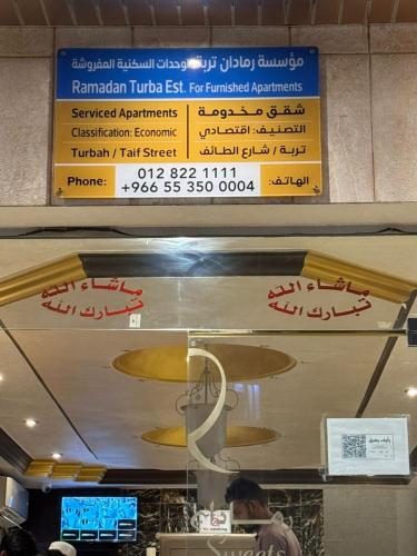 a sign on the ceiling of a fast food restaurant at رمادان تربة للشقق المخدومة in Turbah