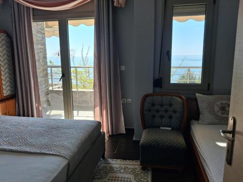 a bedroom with a bed and a chair and a window at Villa Alexander in Xanthi