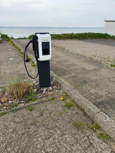 a pay phone sitting on the side of a road at Meerblickappartement mit Ladesäule in Glücksburg