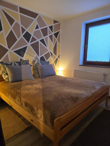 a bedroom with a large bed with a geometric headboard at Apartment Hosner in Lepena