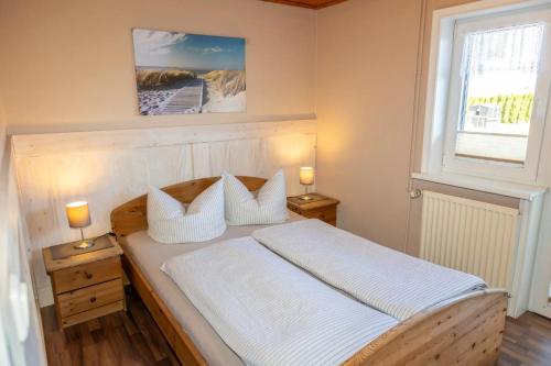 a bedroom with a bed with two lamps on tables at Familien-Ferienanlage Seefeldt in Freest
