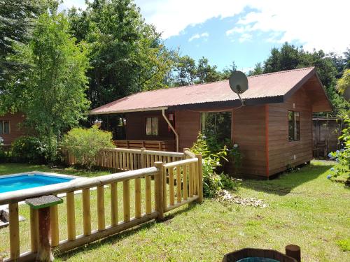 a small house with a pool in the yard at Cabañas Santa Maria Pucon in Pucón