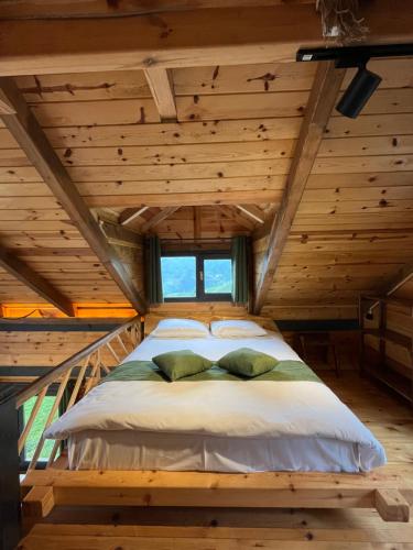 a bed in a room with a wooden ceiling at Pisa Villa-Bungalov in Topluca