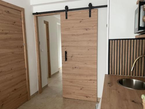 a bathroom with a wooden sliding door in a room at Entre Murallas in Doña Mencía