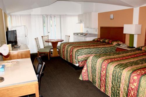 um quarto de hotel com duas camas e uma mesa em Warm Mineral Springs Motel em North Port