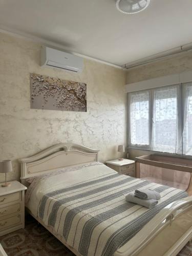 a bedroom with a bed with a striped blanket at Central City Apartment of Asti in Asti