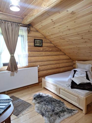 a bedroom with a bed in a wooden cabin at Cabana La Bălănuț din Bucovina in Colacu