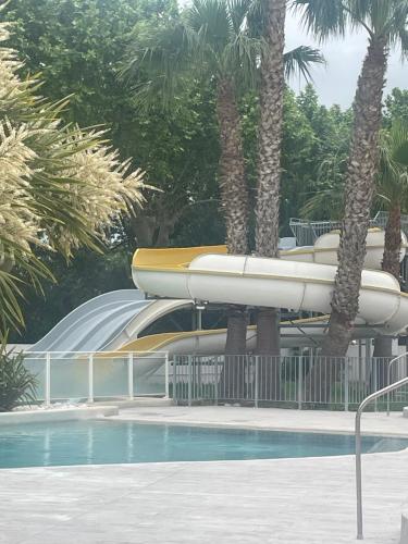 a water slide in a resort with a pool at Mobilhome Ligaropa climatisé 3 ch 6 pers camping des 7 fonts in Agde