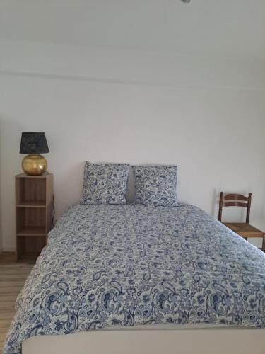 a bedroom with a bed with a blue comforter at Gite des Capucines in Bourbourg