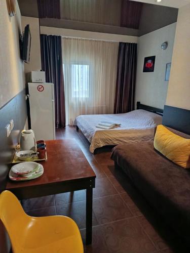 a hotel room with two beds and a table and a chair at Genuez in Odesa