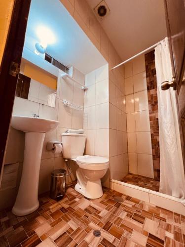 a bathroom with a toilet and a sink and a shower at PAKARI Wasi in Cusco