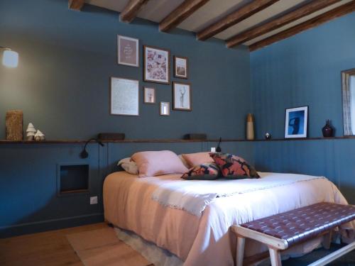 a bedroom with blue walls and a bed with a bench at Chambres d'hôtes l'allegra in Saint-Euphrône