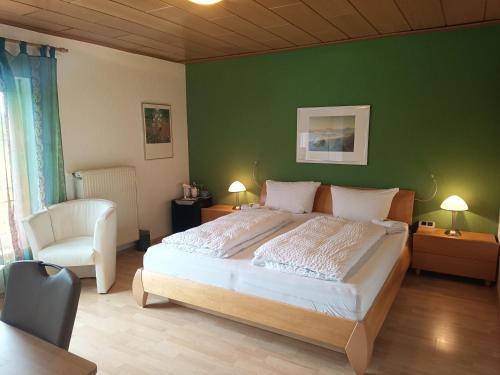 a bedroom with a large bed and a green wall at Weingut Villa Raevenhof in Ayl