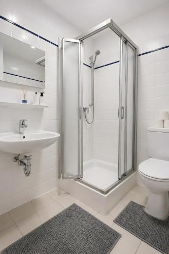 a bathroom with a shower and a toilet and a sink at Terrasse Double Studio Apartments in Lübeck