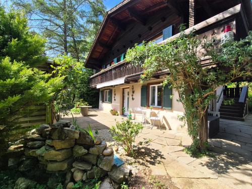 a house with a stone wall in front of it at Casa del Sole Apartments - Ruhig - Nähe Interlaken in Spiez