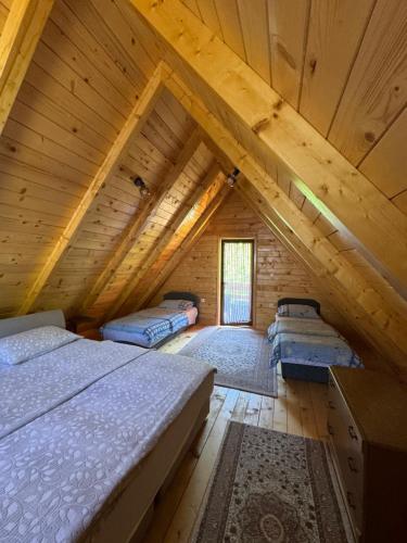 a room with three beds in a log cabin at Apartmani Kajkut in Banja Luka