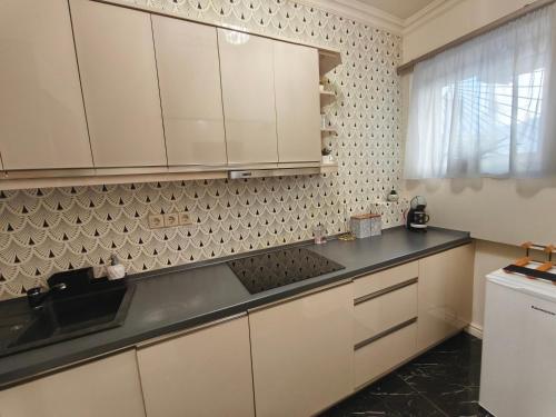 a kitchen with white cabinets and a black counter top at Stylish Apartment in Downtown Budapest in Pusztavacs
