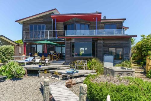 a house on the beach with a deck at Absolute Beachfront B&B in Napier