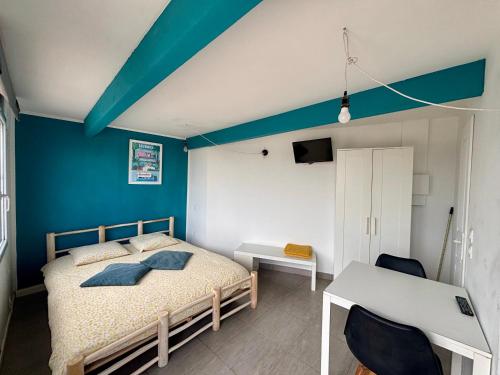 a bedroom with a bed and a blue wall at Ô Bord de Mer ! in Hyères