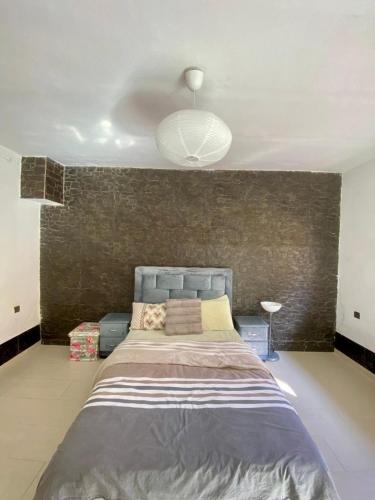 a bedroom with a large bed with a wall at Loft a cinq minute de la plage in Temara