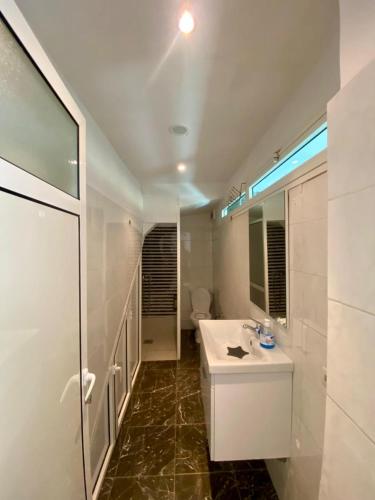 a bathroom with a white sink and a mirror at Loft a cinq minute de la plage in Temara