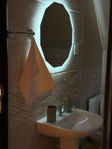 a bathroom with a sink and a pyramid shaped mirror at Greenside Buknari in K'veda Ulianovka