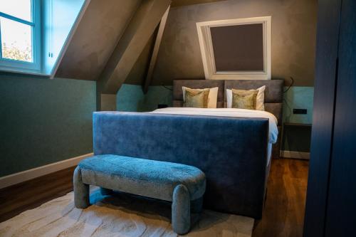 a bedroom with a bed and a blue foot stool at Room4 in Maurik