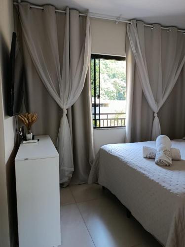 a bedroom with a bed and a television and a window at Apartamento de dois quartos centro de Pomerode in Pomerode